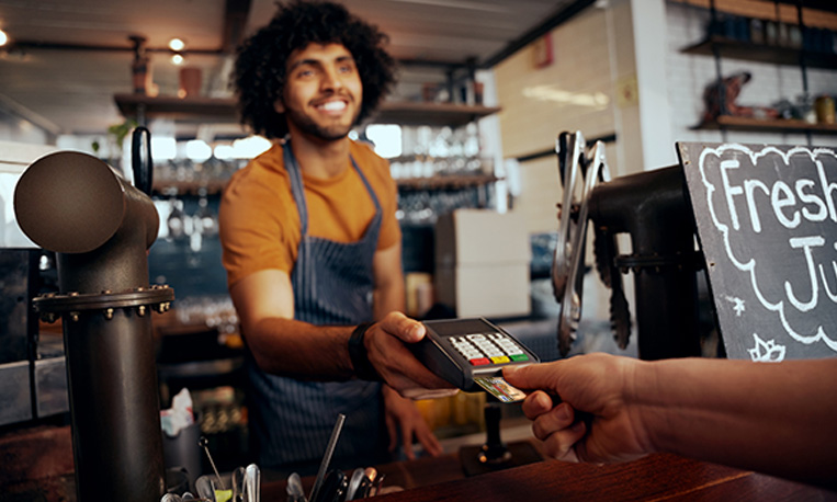 A person using their card at a coffee shop