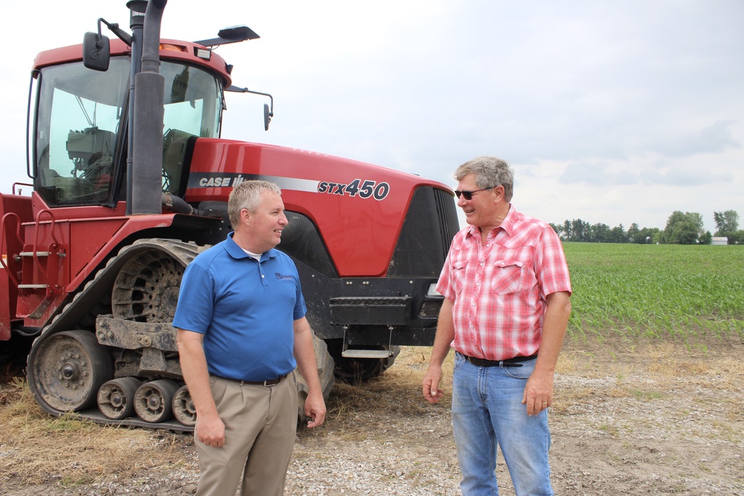 Craig and Joe talking in front of tractor