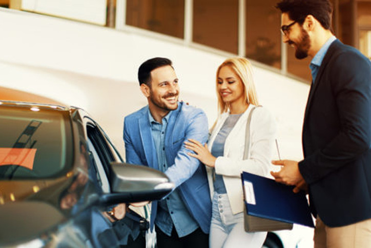 auto loan image A salesman showing a couple a protentional vehicle