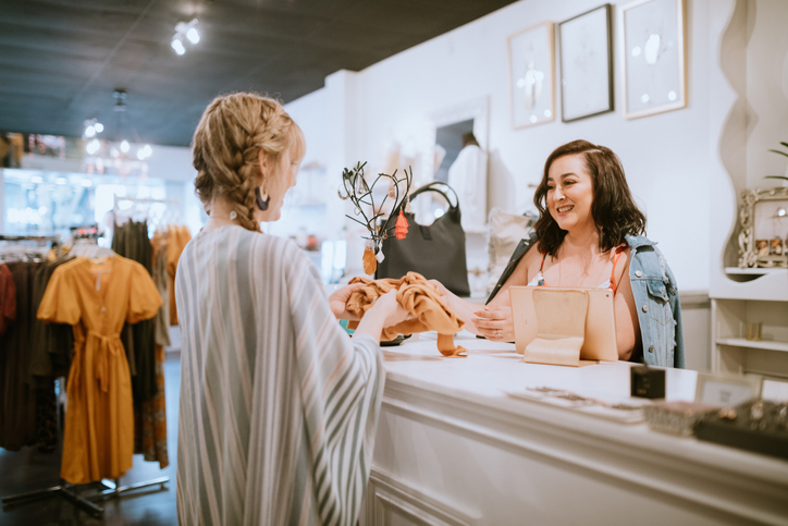 Latina Boutique Store Owner At Checkout Counter A female customer being helped in an established business.
