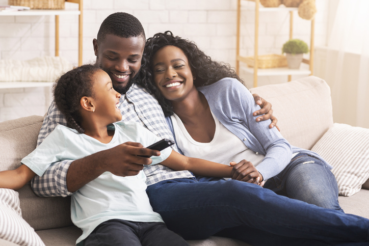Happy african american family relaxing and watching TV at home Family image for Share Certificates