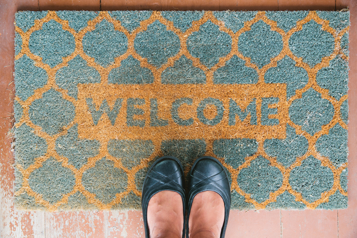 A person standing on a welcome mat